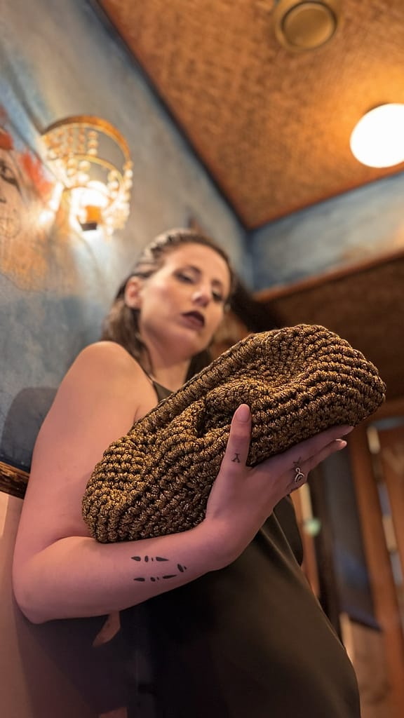 Model carrying Colette bag Model carrying Colette crochet bag in vintage gold